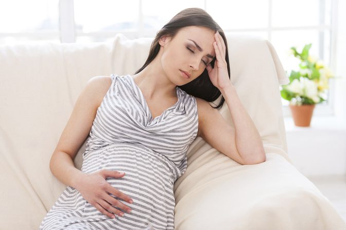 беременная женщина держится за живот