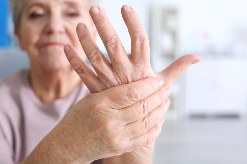 пожилая женщина держит свою левую руку