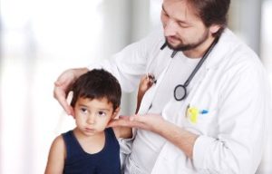 врач осматривает шейные лимфоузлы у ребёнка