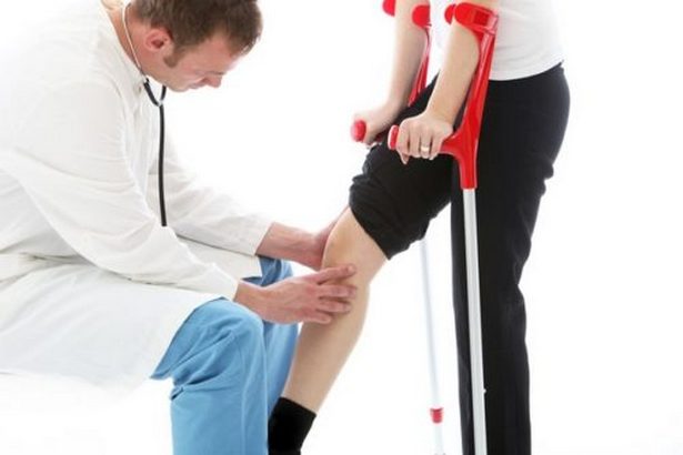 Обследование колена врачом 