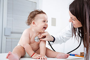 Laughing baby examined by female doctor