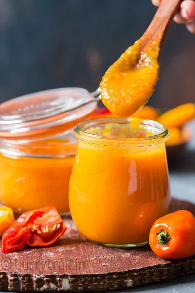 mango habanero hot sauce in a jar with wooden spoon