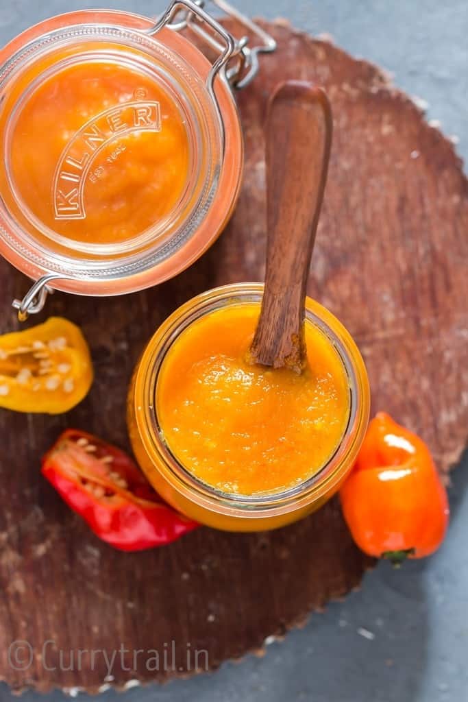 mango habanero hot sauce in a jar with wooden spoon