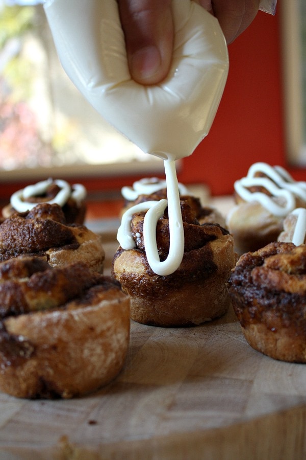 adding cream cheese frosting to No Yeast Cinnamon Rolls