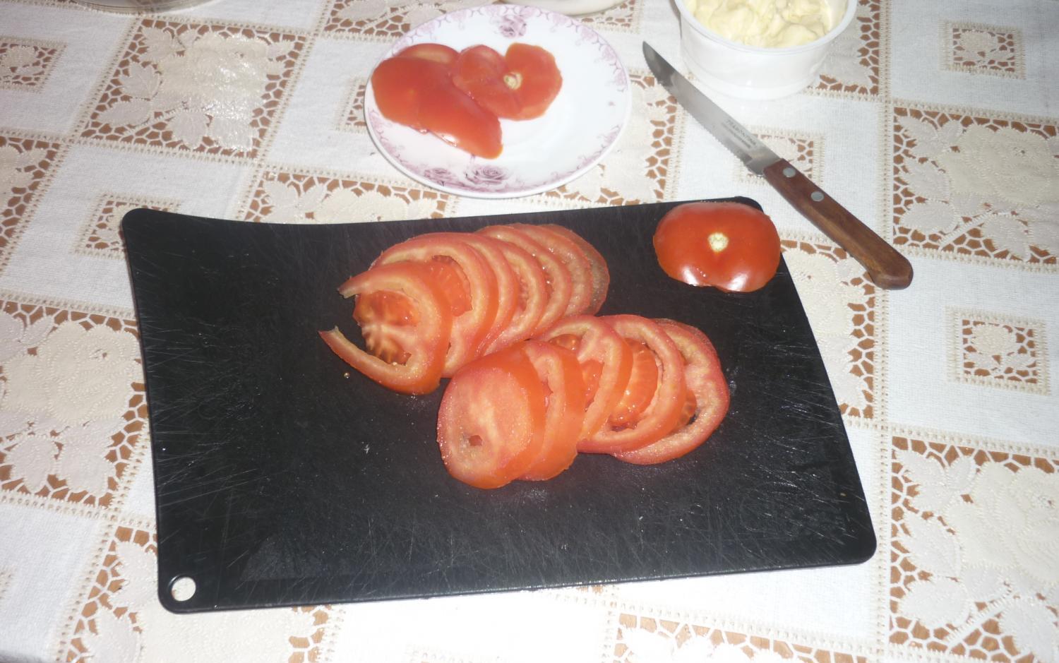 помидор, нарезанный кружочками на черной доске